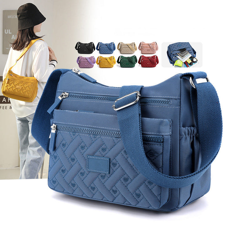 Elegant svart dameskulderveske i nylon med justerbar stropp.