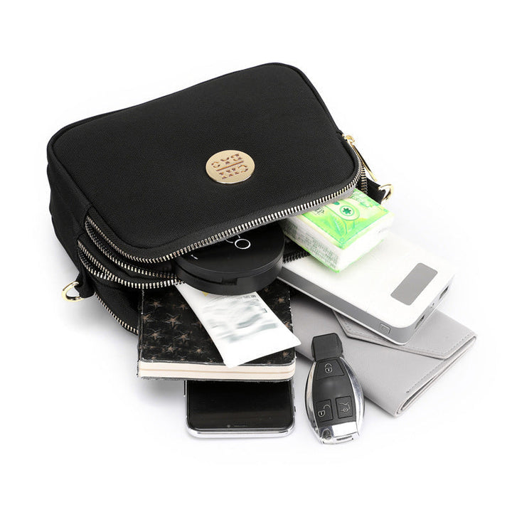 Innvendig visning av romslig nylon messengerbag med mange organiseringslommer.