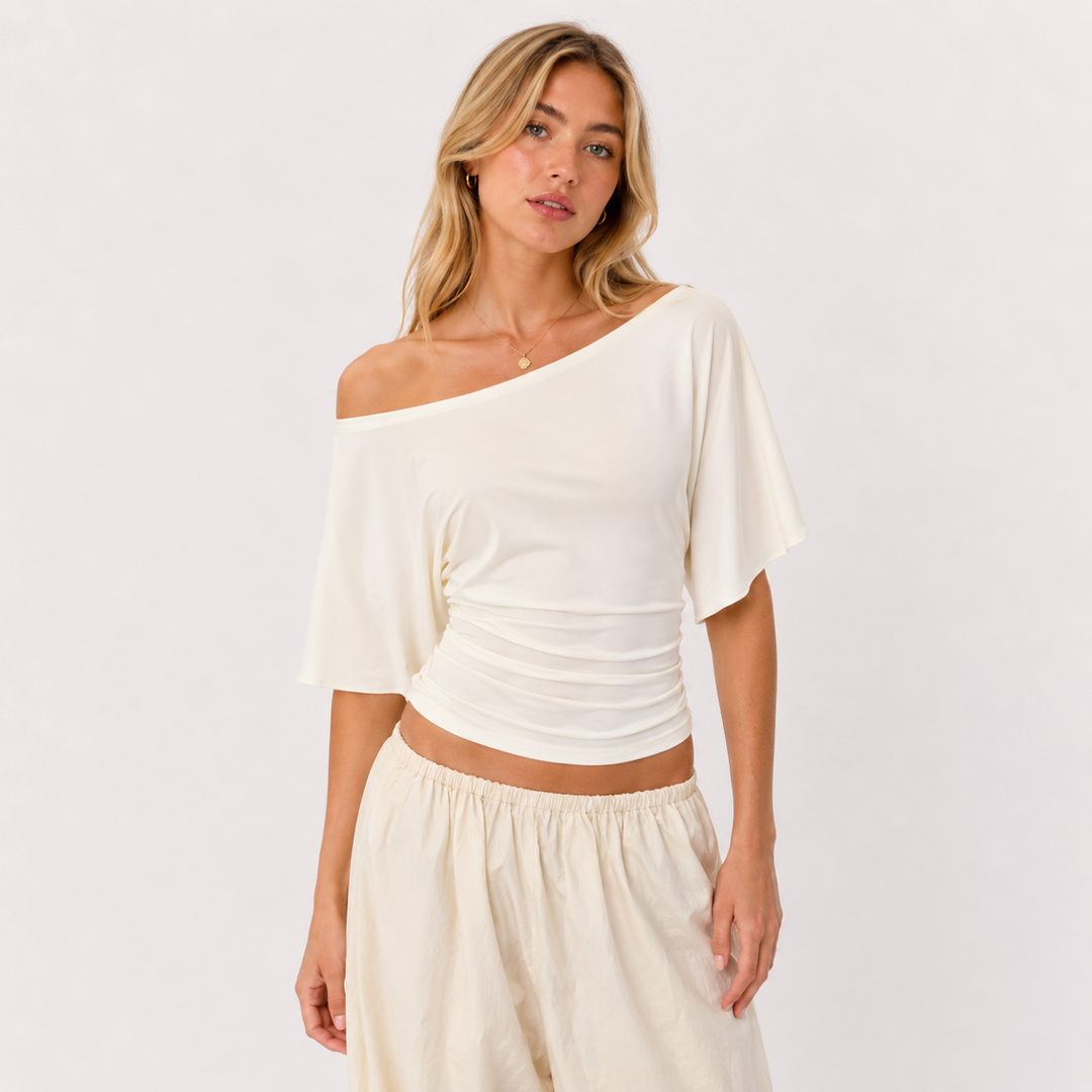 Elegant kortermet dametopp med figurnær passform og stilig knytedetalj i ryggen, perfekt for sommer.