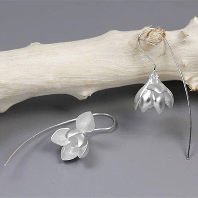 Feminine dingleøredobber med magnolia blomst design. Et elegant tilbehør for kvinner.