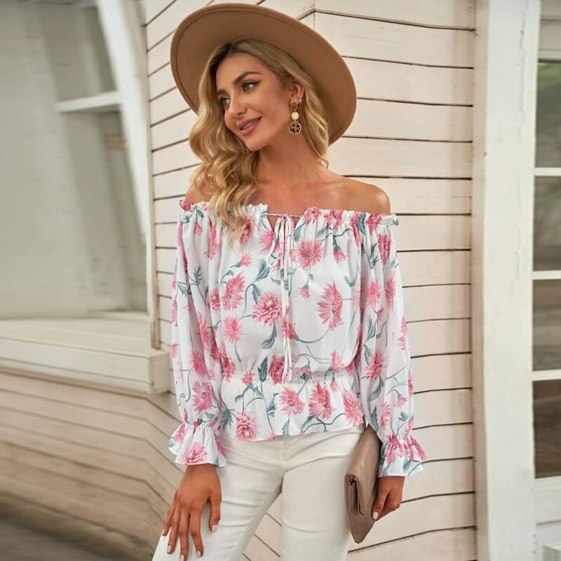 Lett og løs off-shoulder bluse med blomster og volanger. Perfekt for varme sommerdager og avslappet stil.