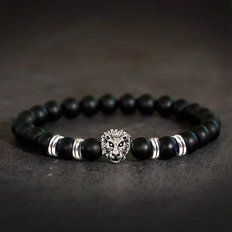 Symbolsk løvearmbånd i dyp sort onyx og stål, representerer åndelig styrke og beskyttelse.