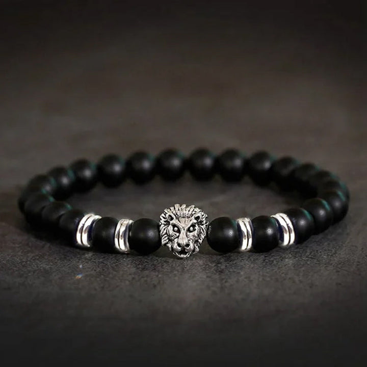 Symbolsk løvearmbånd i dyp sort onyx og stål, representerer åndelig styrke og beskyttelse.