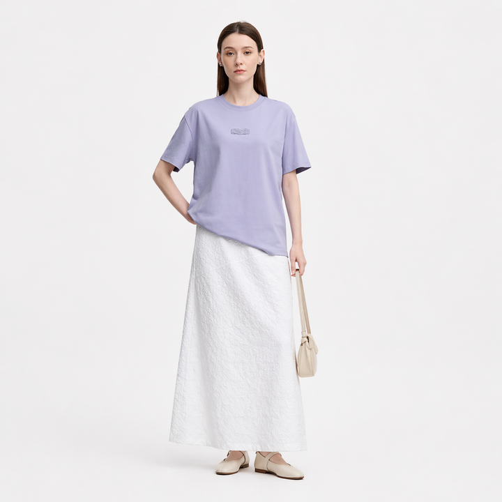 Dame t-skjorte i bomull med unikt print, løs passform og stilig drop shoulder, perfekt for sommer.