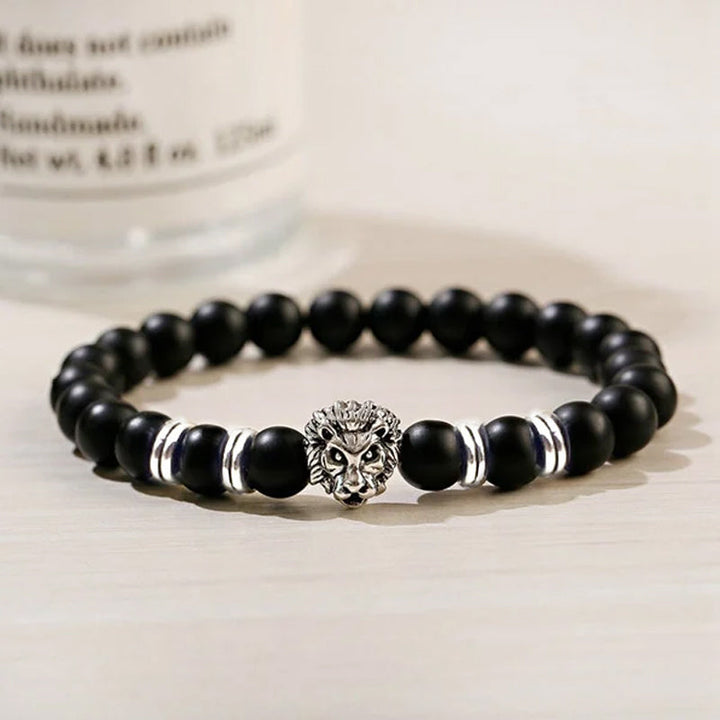 Nærbilde av unisex løvearmbånd med glatte onyx-kuler og detaljert løvehode i rustfritt stål.