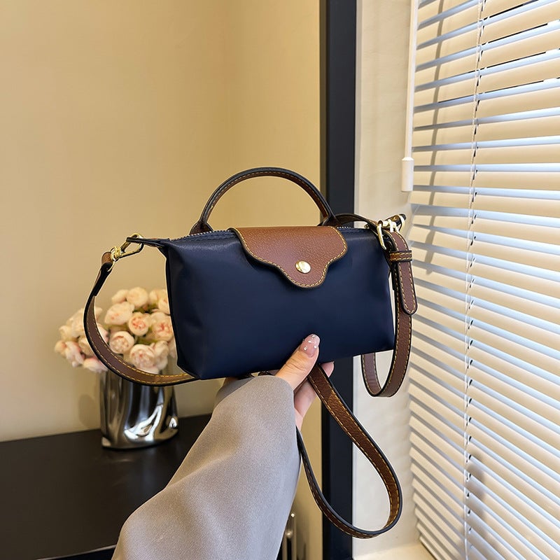 Unik fargeblokk design på denne elegante mini crossbody vesken i slitesterk nylon.