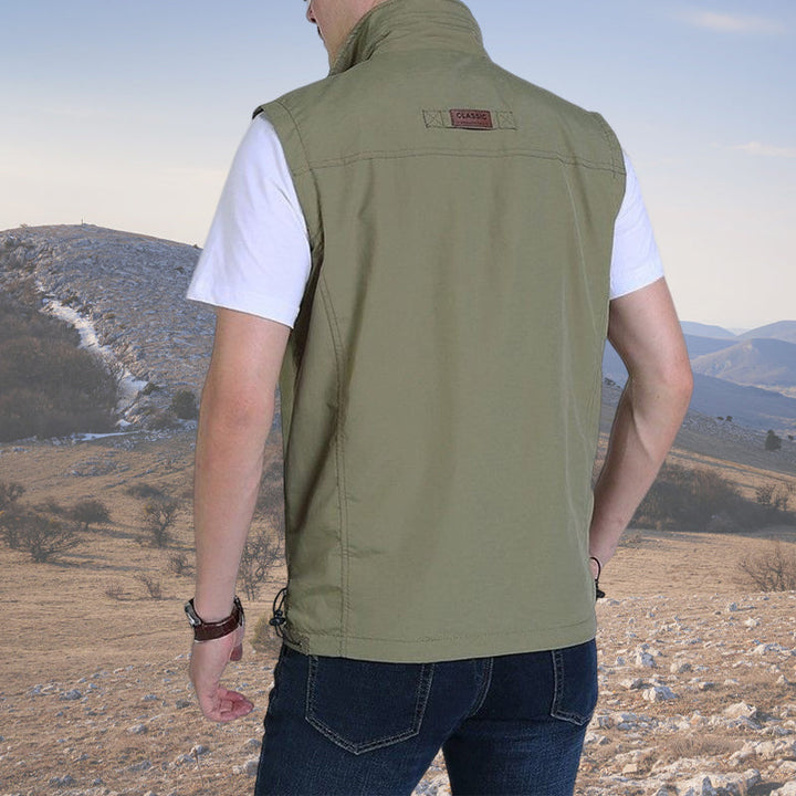 Mann klatrer i vanntett herrevest. Ergonomisk lettvekt softshell vest for friluft og krevende terreng.