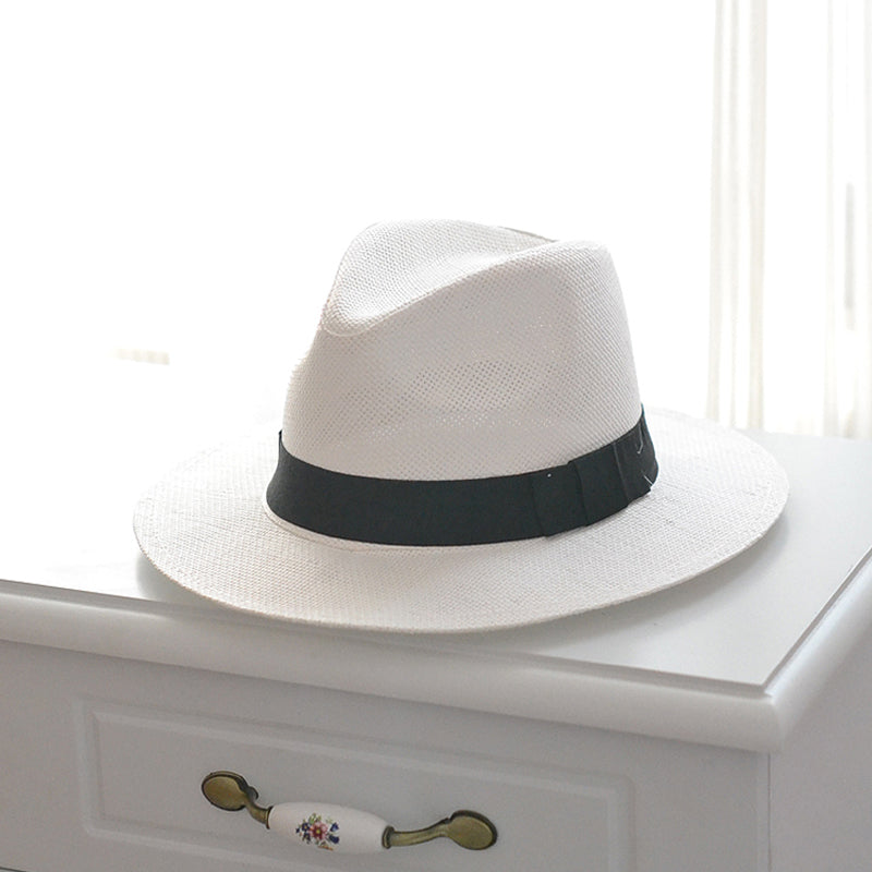 Elegant sommerhatt i aprikos og hvit med bred kant, ideell for hage, strand eller by.