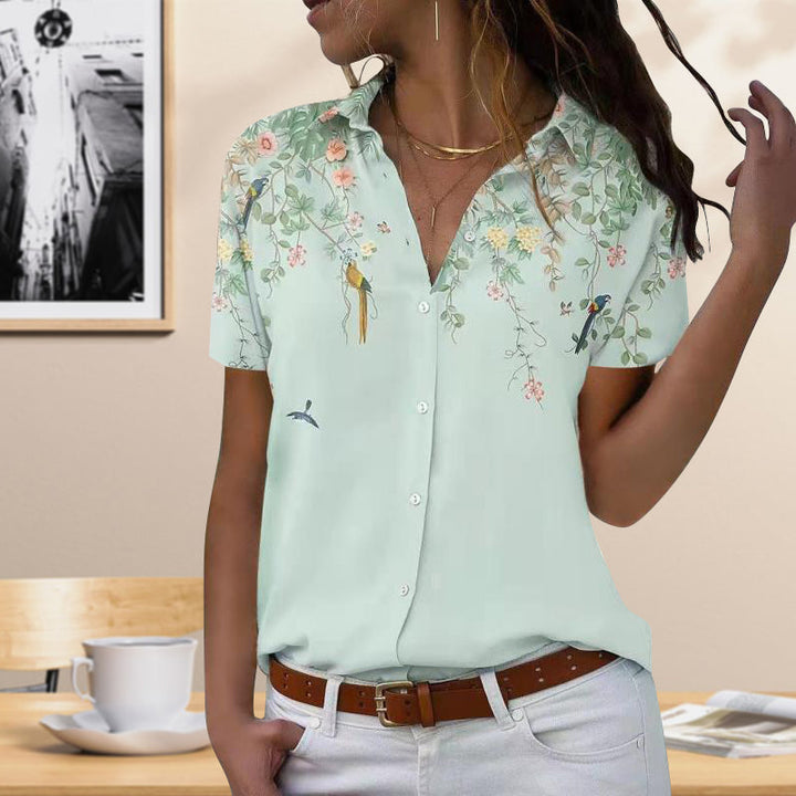 Marineblå kvinnebluse med blomstermønster, kortermet og elegant for sommer.