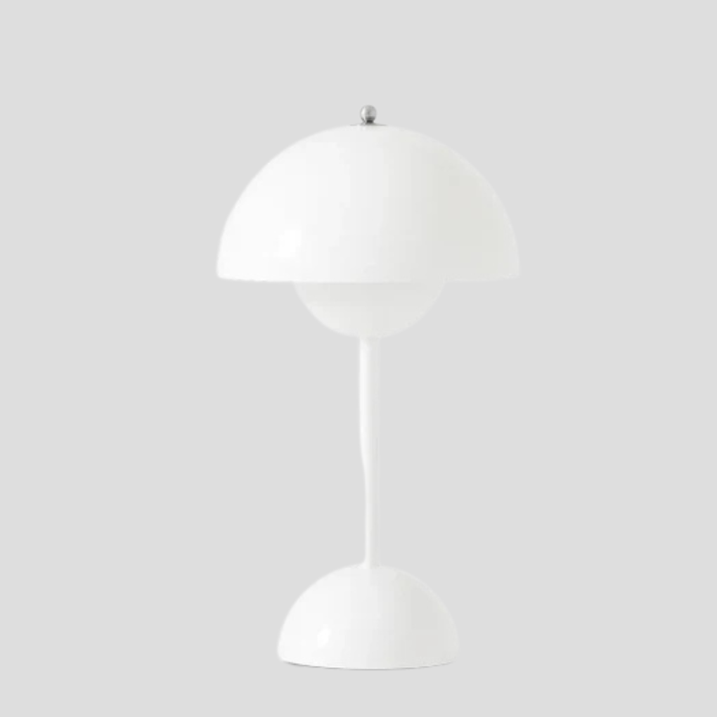 Oppladbar trådløs metall-bordlampe på terrassebord. Ideell som fleksibel utendørsbelysning for hyggelige kvelder.