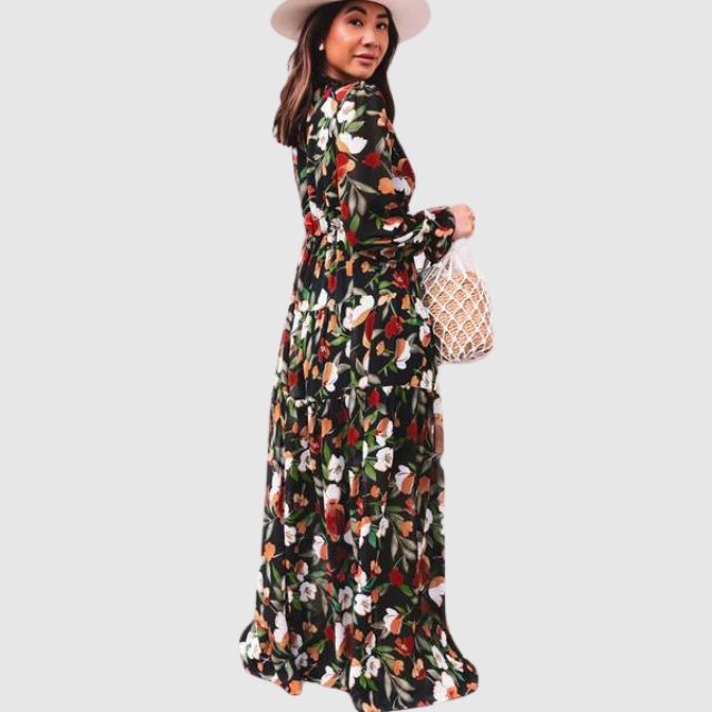 Kvinne iført rød elegant blomstret chiffon maxikjole. Perfekt sommerfestkjole med flytende design.