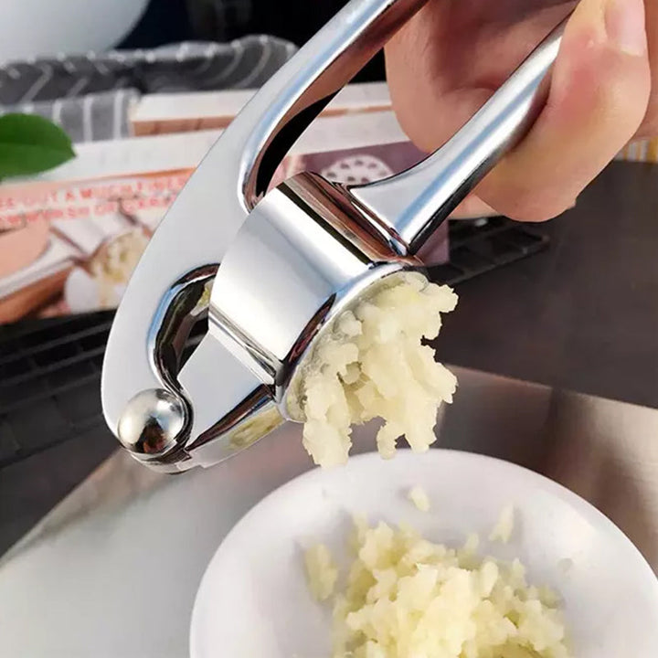 Stilig, ergonomisk hvitløkshakker på benken; moderne kjøkkenutstyr som forenkler matlaging.