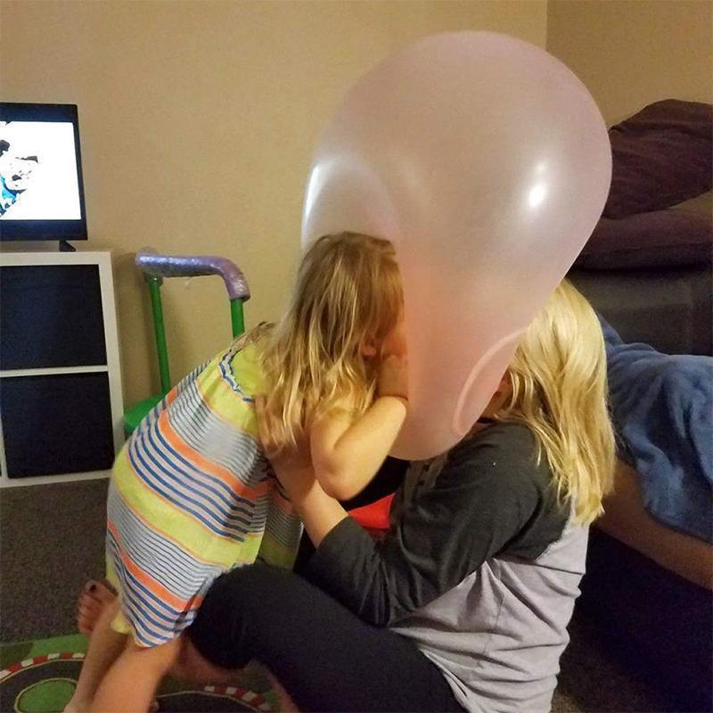 En enslig oppblåsbar gigantball på en eng, symboliserer moro og aktiv utelek for hele familien.
