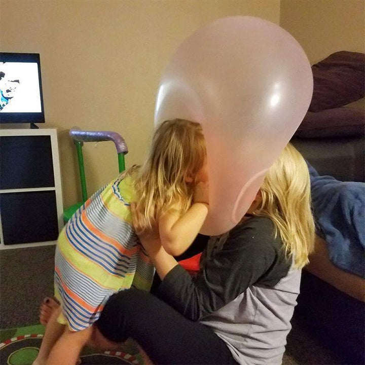 En enslig oppblåsbar gigantball på en eng, symboliserer moro og aktiv utelek for hele familien.