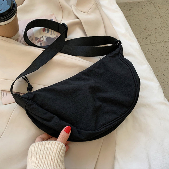 Unik halvmåneformet crossbody-veske, elegant og moderne unisex design, et populært tilbehør.