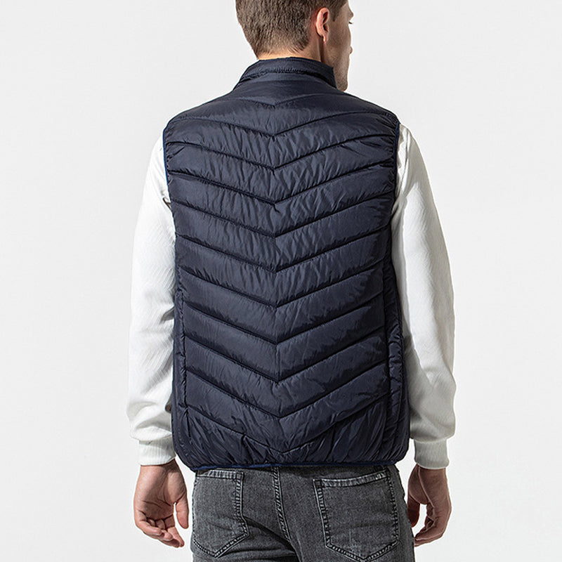 Bilde av en person som bruker svart unisex oppvarmet vest under en jakke.