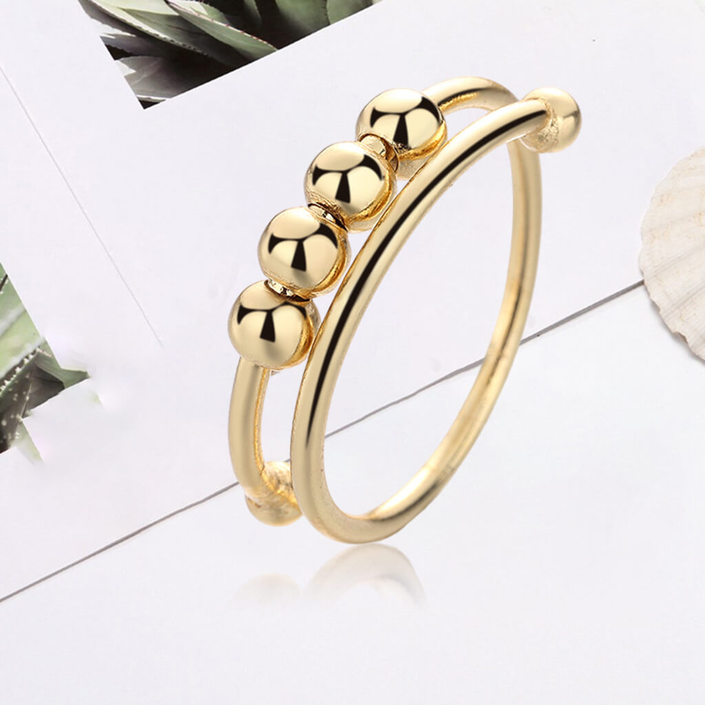 Hånd holder justerbar dame fidget-ring i sølv, perfekt for stressreduksjon og daglig bruk. Smykke.