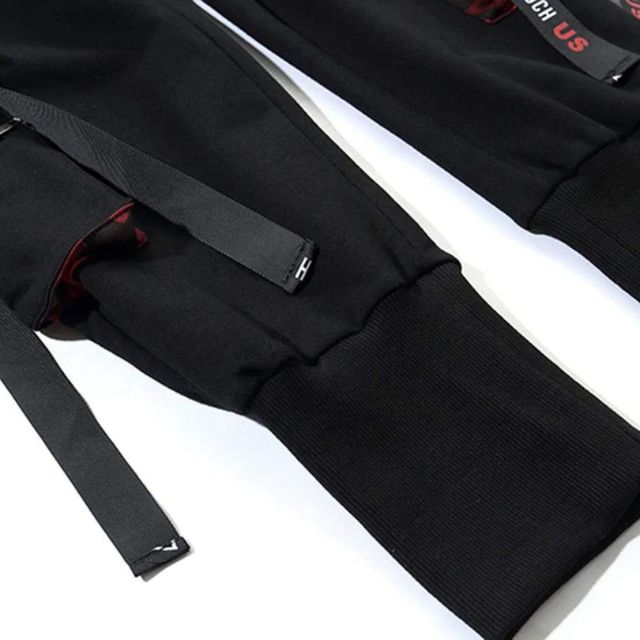 Brettet sort unisex streetwear joggebukse med stropper; klar for bruk.