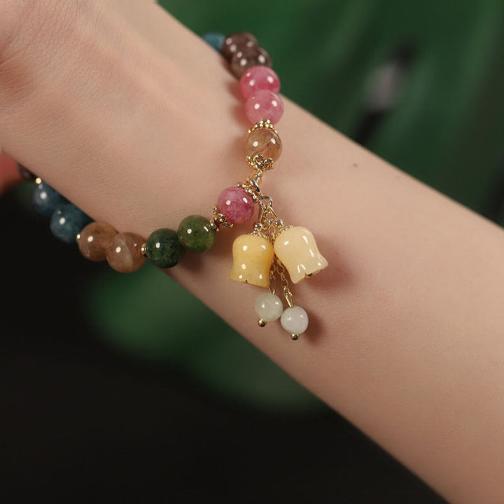 Kvinne med fargerikt turmalin armbånd på; et stilfullt og energisk natursteinsmykke.