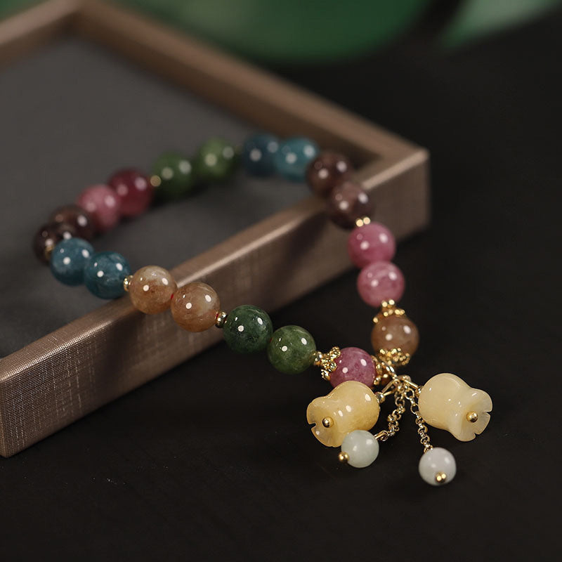 Nærbilde av turmalin armbåndets fargerike natursteiner. Viser unik tekstur og glans.