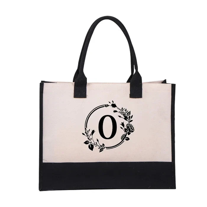 Funksjonell toteveske i canvas med unikt bokstavdesign, allsidig for alle anledninger.