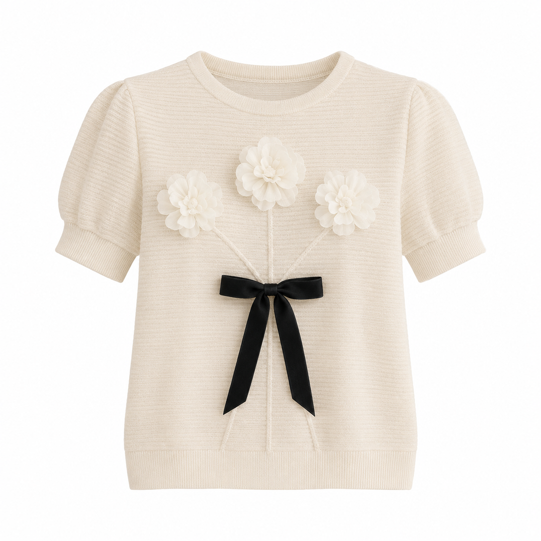 Svart plissert dametopp med stilige puffermer og delikate 3D-blomster. En tidløs elegant hverdagstopp.