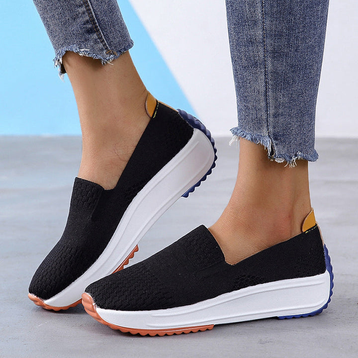 Stilren slip-on sportssko for kvinner i flystrikk, med fokus på komfort og smertelindring.