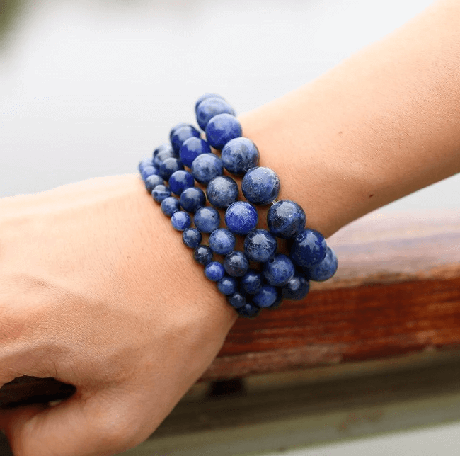 Tigerøye armbånd av edelstener, avbildet med naturlige elementer for balanse.