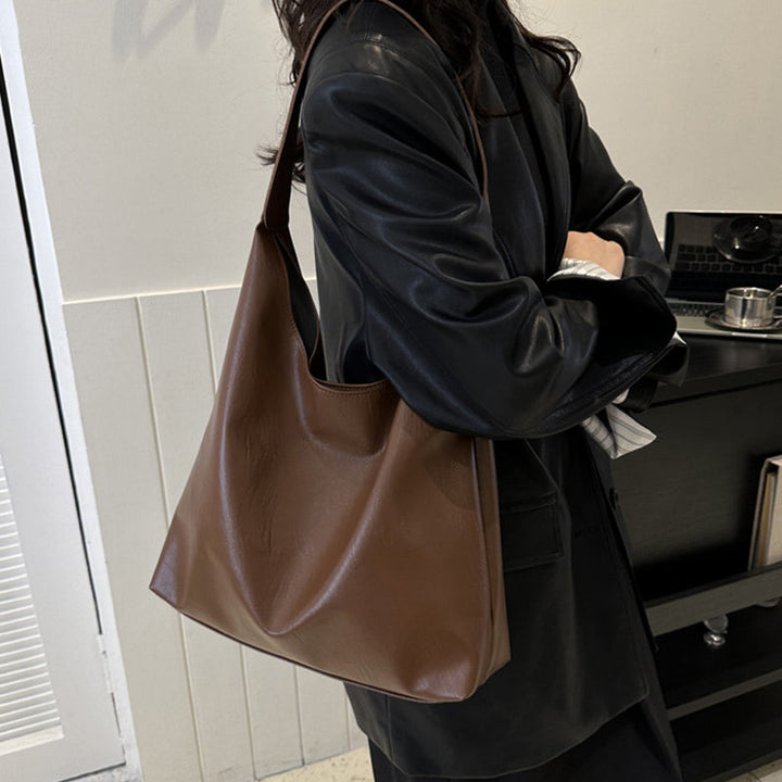Brun messengerbag i elegant skinnimitasjon, romslig og komfortabel til hverdags.