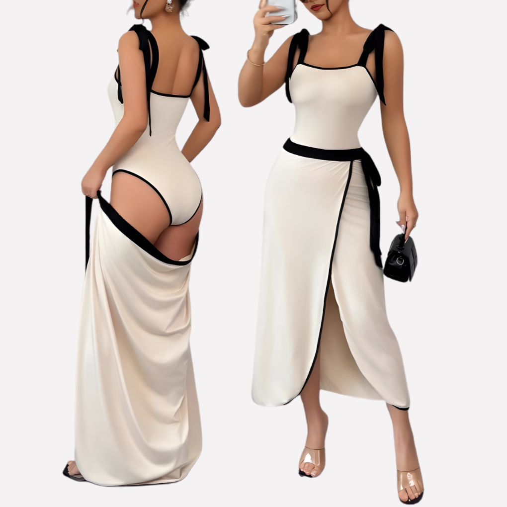 Elegant hvit jumpsuit for kvinner med strappy asymmetrisk design og svart kontrastkant. Perfekt sommer- eller festantrekk.