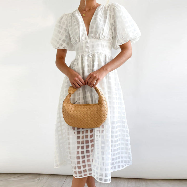 Klassisk elegant damekjole med puffermer, knelang lengde og delikat kvadratisk mønster.