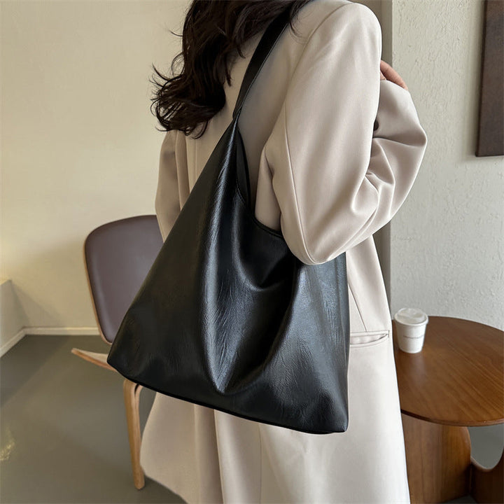 Brun ensfarget messengerbag i skinnimitasjon, perfekt som elegant hverdagsvse for kvinner.
