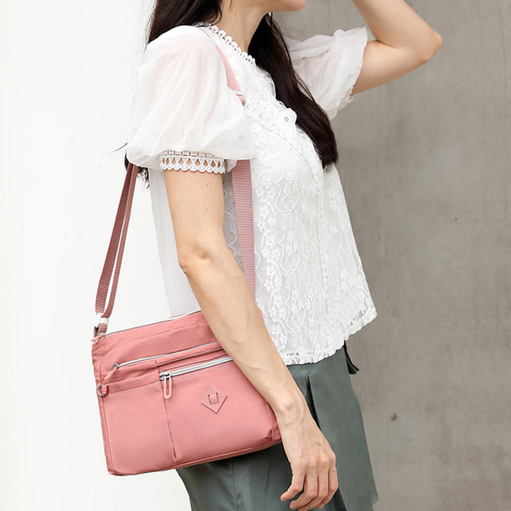 Vanntett crossbody messenger bag for kvinner med mange praktiske rom.