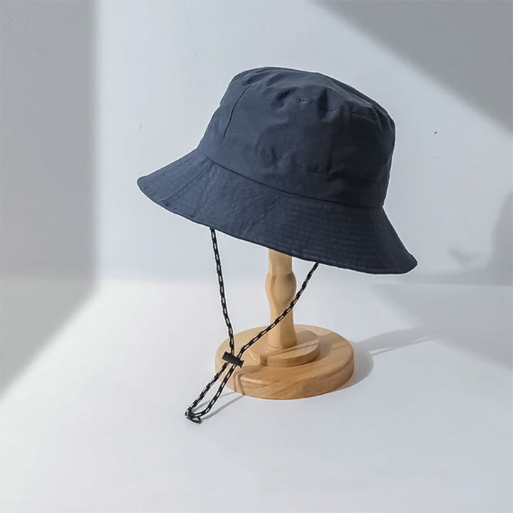 Sammenfoldet solhatt i polyester, viser hvor kompakt den er for reise og praktisk oppbevaring.