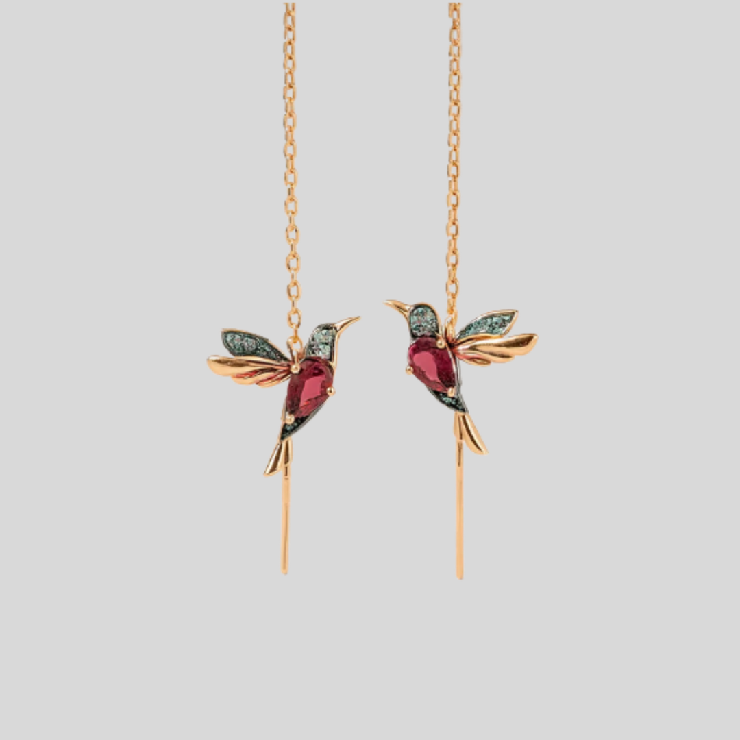 Elegante kvinners kolibri drop øreringer med glitrende krystaller. Gullfargede fugleøreringer med unikt design.