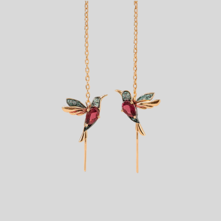 Elegante kvinners kolibri drop øreringer med glitrende krystaller. Gullfargede fugleøreringer med unikt design.