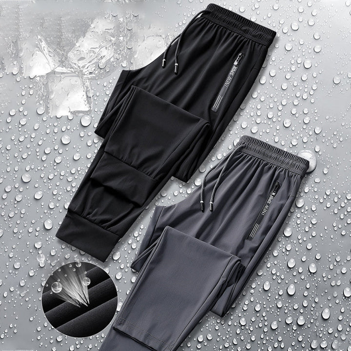 Svarte, komfortable unisex sportsbukser med stretch, hurtigtørkende funksjon og tapered passform.