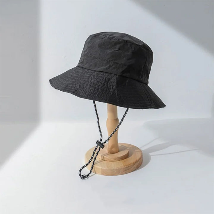 Nærbilde av det slitesterke polyesterstoffet på den UV-beskyttende sammenleggbare solhatten.