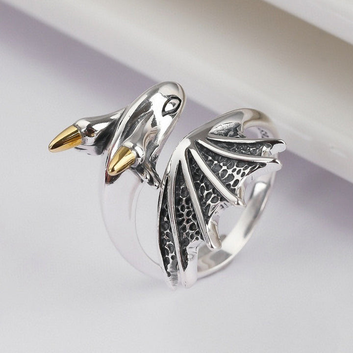 Hånd som bærer den justerbare drage ringen, et allsidig unisex smykke i skinnende metall.