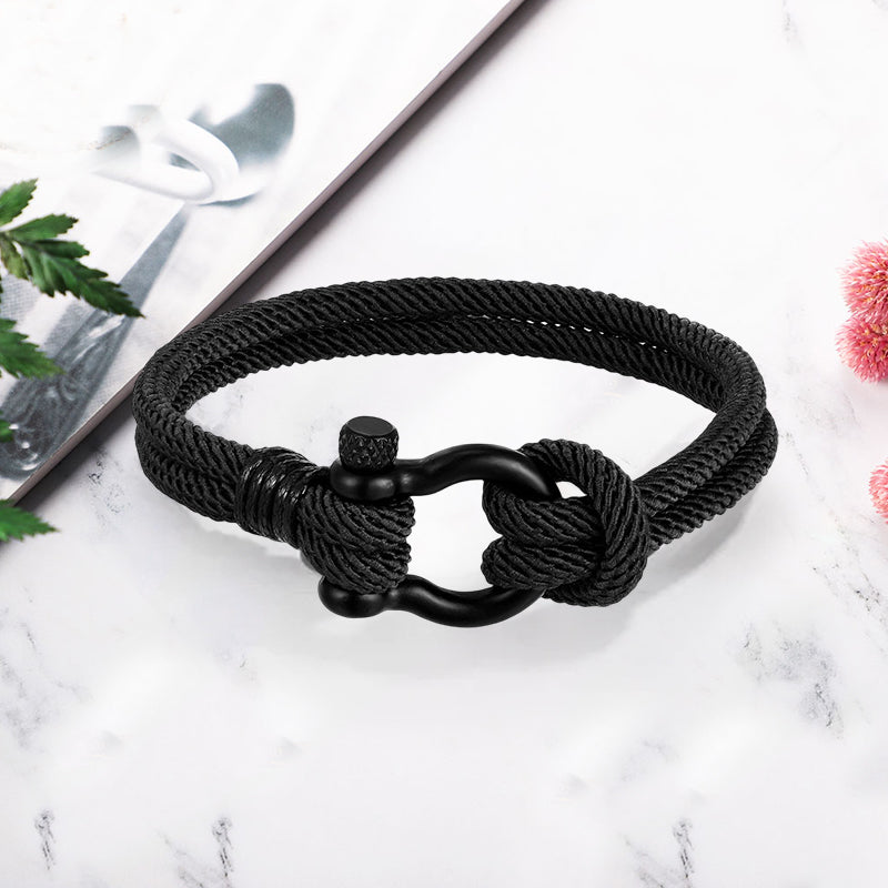 Nærbilde: Nautisk anker på flettet unisex tauarmbånd, viser kvalitet og design.