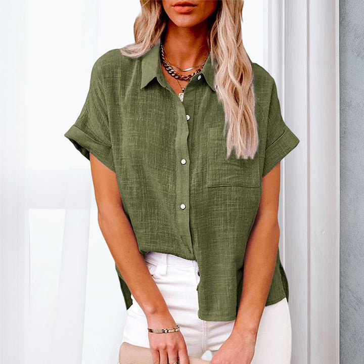 Elegant arbeidsskjorte for kvinner, kortermet og ensfarget. Stilren bluse med diskrete lommer.