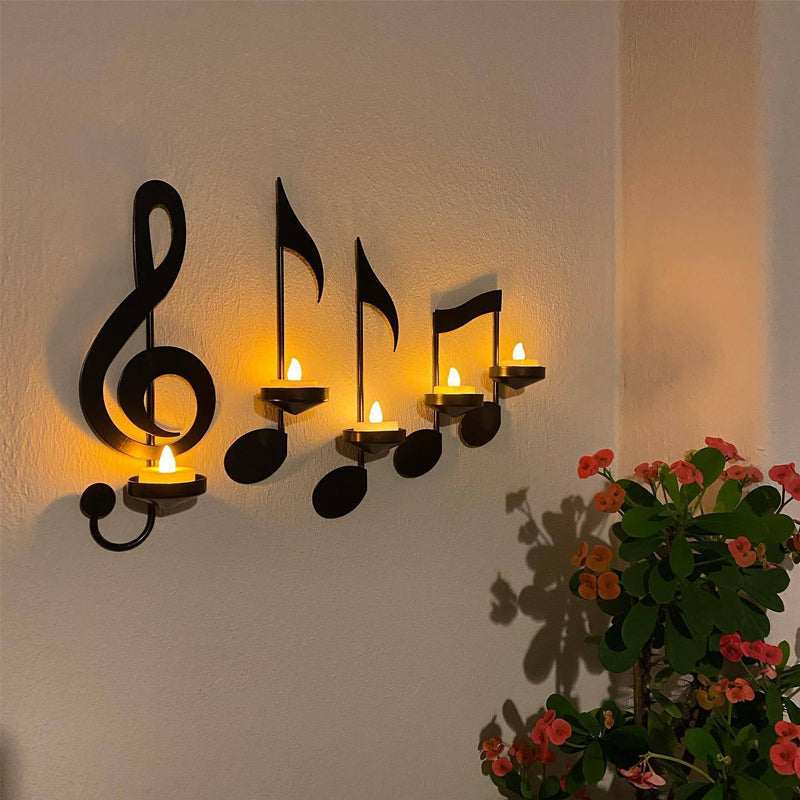 Svart metall vegglysestake med musikknoter og g-nøkkel design. Elegant veggdekor for hjemmet.