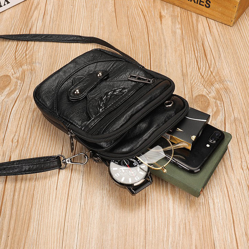 Svart, kompakt crossbody-veske for dame, perfekt størrelse for mobil og nøkler.
