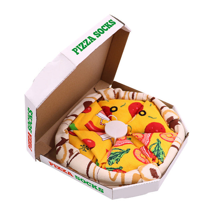 Hånd som holder en av de unike pizzasokkene fra 4-pakningen, som leveres i en kreativ pizzaboks.