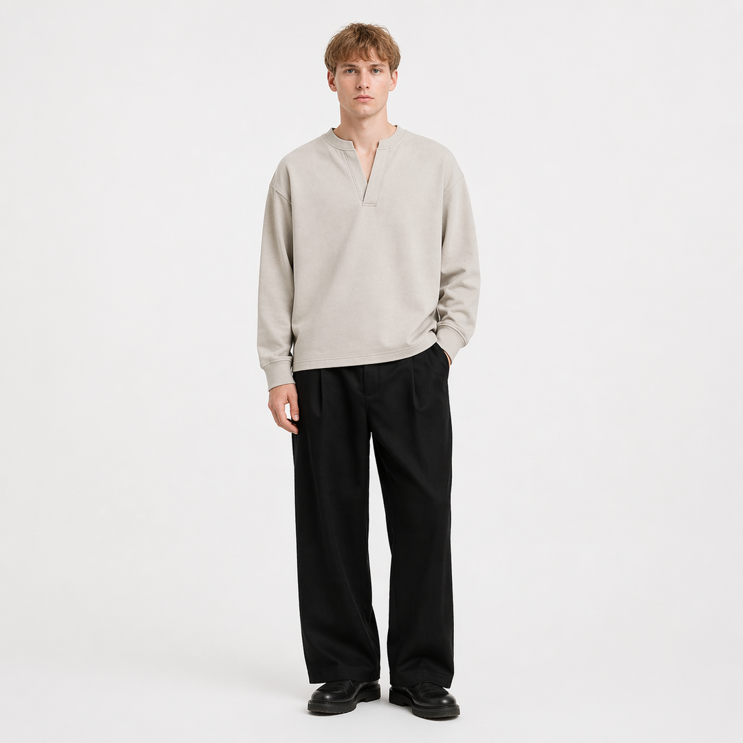 Mann iført en stilig, langermet Henley t-skjorte. Komfortabel herreskjorte med minimalistisk design for avslappet look.