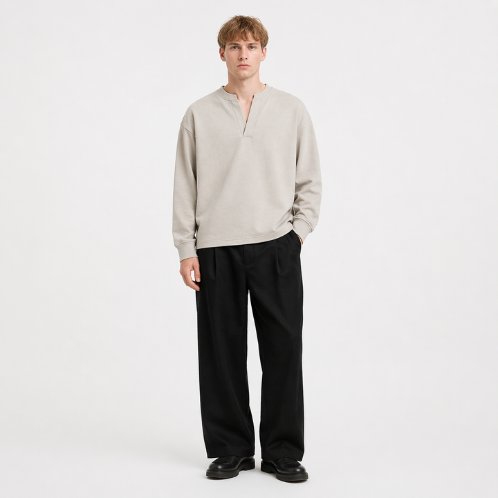 Mann iført en stilig, langermet Henley t-skjorte. Komfortabel herreskjorte med minimalistisk design for avslappet look.