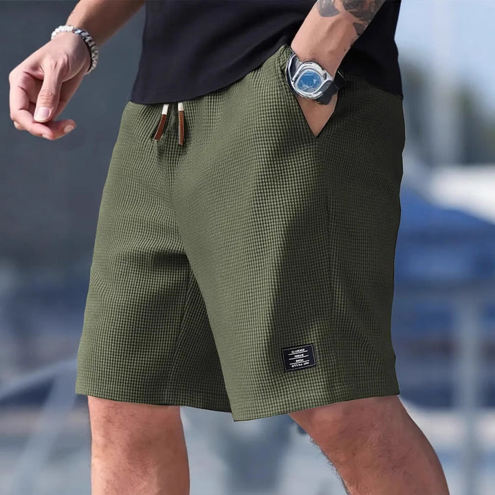 Stilige menns sportsshorts for trening, løping og utendørsaktiviteter. Med praktisk snøring og dype lommer.