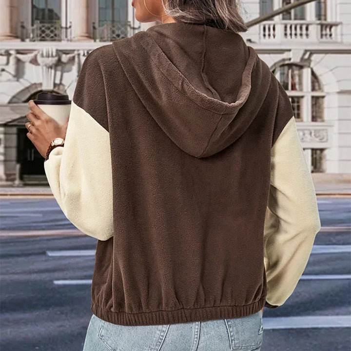 Casual brun damejakke i polarfleece med hette. Trendy lappeteppedesign for høst og vinter yttertøy.
