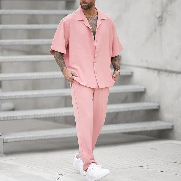 Komfortabelt herre fritidssett i rosa polyester, kortermet og todelt for sommeren, perfekt for casual bruk.