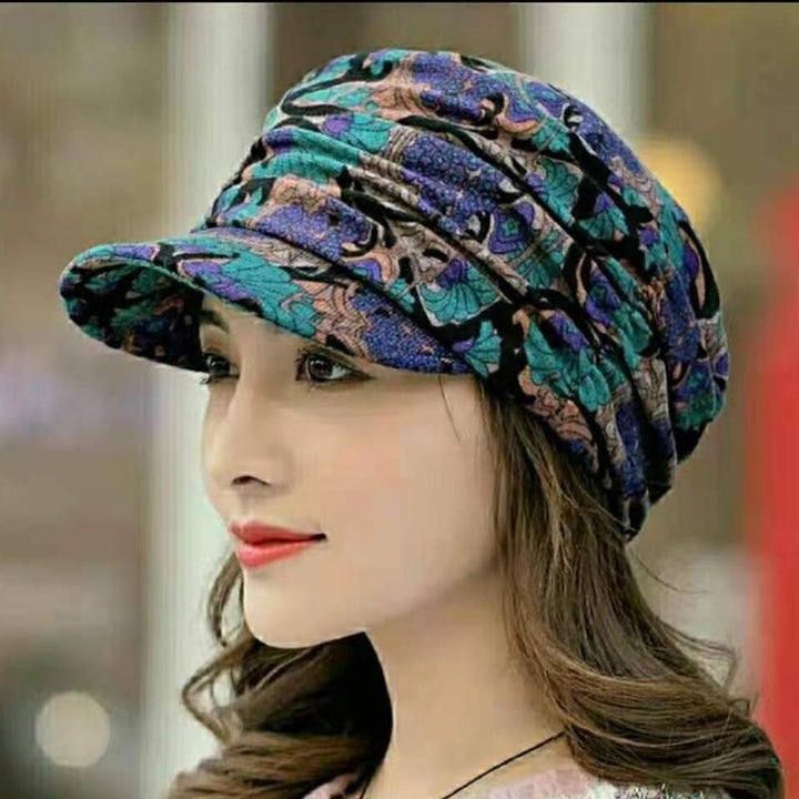 Elegant damehatt i plissert design. Blomstret mønster gir et feminint preg. Ideell høstlue.